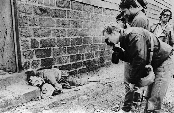 Fotógrafo e operador de câmera registram um curdo segurando um bebê, ambos mortos, em uma rua de Halabja, no nordeste do Iraque, em 20 de março de 1988 - Sputnik Brasil