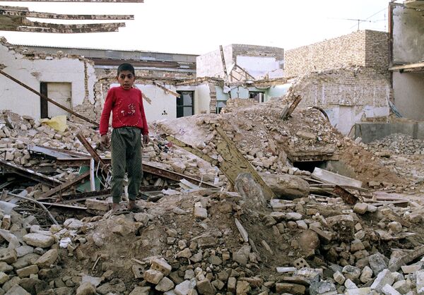 Menino iraniano nas ruínas da sua antiga casa destruída em 23 de janeiro em um ataque aéreo iraquiano em Ahvaz, em 25 de janeiro de 1987 - Sputnik Brasil