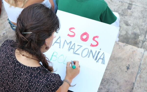 Manifestante escrevendo cartaz durante ato contra queimadas na Amazônia em Lisboa, Portugal - Sputnik Brasil