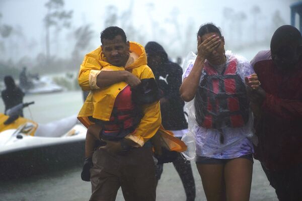 Família é escoltada para zona segura depois de ser resgatada durante o furacão Dorian, na cidade de Freeport, Bahamas, 3 de setembro de 2019 - Sputnik Brasil