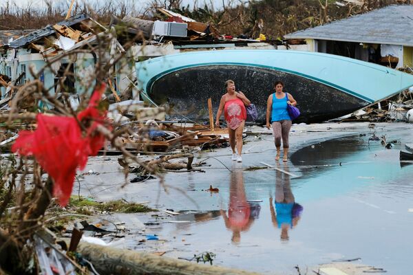 Mulheres andam entre destroços deixados pelo furacão Dorian em uma das ilhas Bahamas - Sputnik Brasil