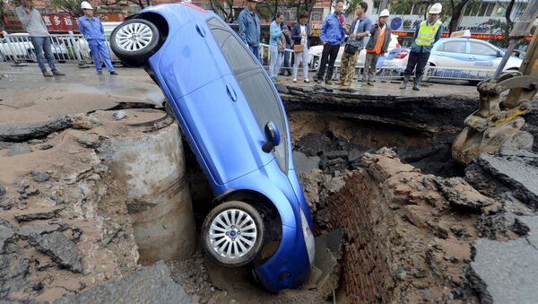 Carro é engolido por cratera aberta no meio da rua na província de Gansu, na China (imagem referencial) - Sputnik Brasil