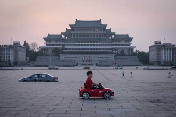Menino em carro de brinquedo na praça de Kim Il-sung em Pyongyang, na Coreia do Norte - Sputnik Brasil