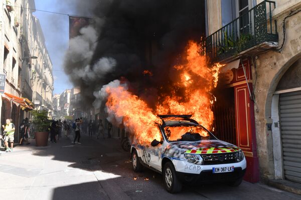 Carro da polícia incendiado por participantes do movimento rebelde coletes amarelos em Montpellier, na França - Sputnik Brasil