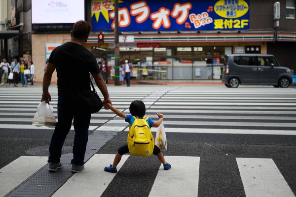 Pai e filho em uma faixa de pedestres na cidade japonesa de Oita, em 21 de setembro de 2019 - Sputnik Brasil