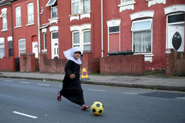 Criança jogando futebol em uma das ruas de Luton, Reino Unido - Sputnik Brasil