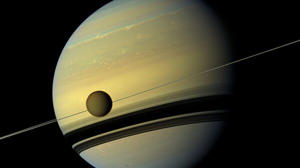 Maior lua de Saturno, Titã, passando em frente ao planeta gigante em imagem feita pela nave espacial Cassini da NASA - Sputnik Brasil