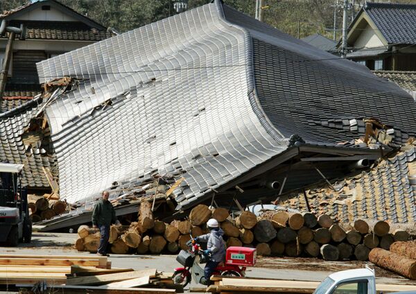 Carteiro se protege para entregar cartas após terremoto na cidade de Wajima, no Japão - Sputnik Brasil