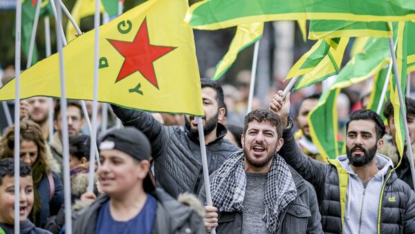Pessoas com bandeiras do YPG protestam contra a operação turca sobre territórios curdos na região norte da Síria em Hamburgo, na Alemanha em 12 de outubro de 2019. - Sputnik Brasil