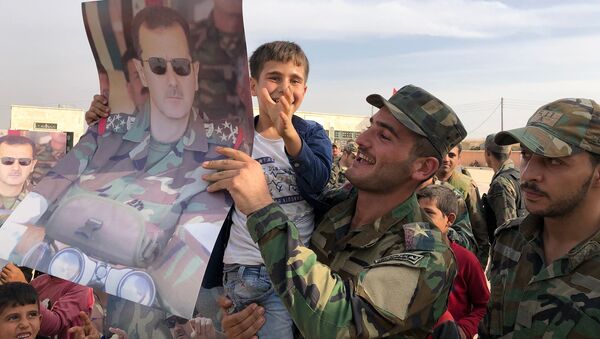 Crianças e militares seguram cartazes com a imagem do presidente da Síria, Bashar Assad, na cidade de Manbij - Sputnik Brasil