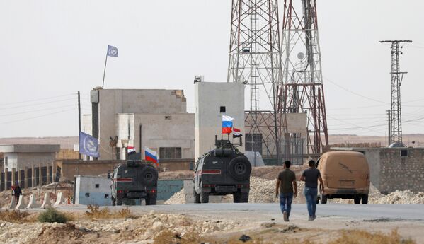 Bandeiras da Rússia e da Síria hasteadas em veículos militares na cidade russa de Manbij, em 15 de outubro de 2019 - Sputnik Brasil