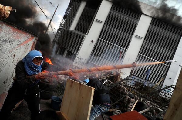 Manifestante atira de uma arma artesanal durante protesto em Quito, no Equador - Sputnik Brasil