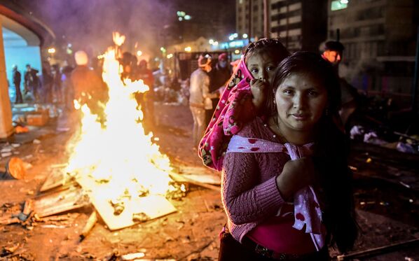 Uma mulher e sua filha durante protestos perto da Casa da Cultura em Quito, no Equador - Sputnik Brasil