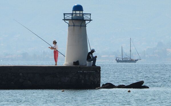 Visitantes pescam perto de farol no Golfo Sul de Eubea no mar Egeu - Sputnik Brasil
