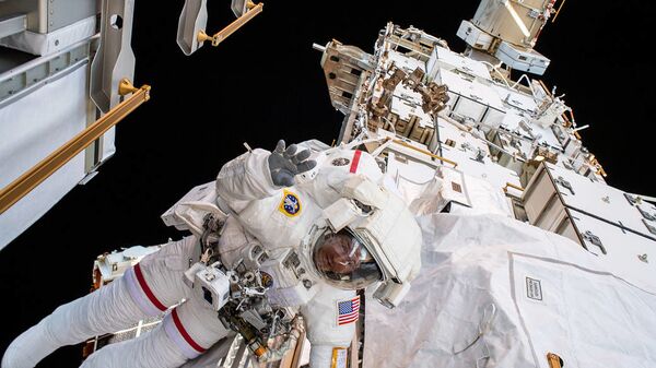 O astronauta da NASA Andrew Morgan acena para a câmera enquanto amarrado na seção P6 da Estação Espacial Internacional (EEI) - Sputnik Brasil