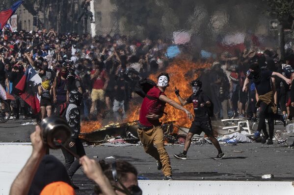 Manifestantes montam barricadas e cobrem o rosto durante protestos no Chile - Sputnik Brasil