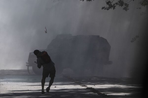 Manifestante atira garrafa contra veículo blindado da polícia do Chile durante protestos - Sputnik Brasil