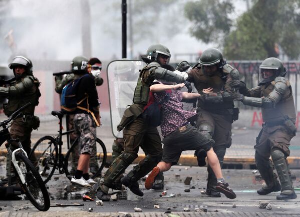 Tropa de choque tenta deter manifestante durante protestos em Santiago do Chile - Sputnik Brasil