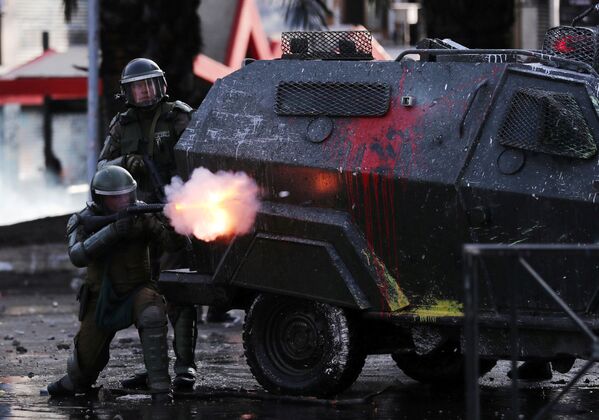 Soldados protegidos por veículos blindados atiram contra manifestantes na capital chilena - Sputnik Brasil