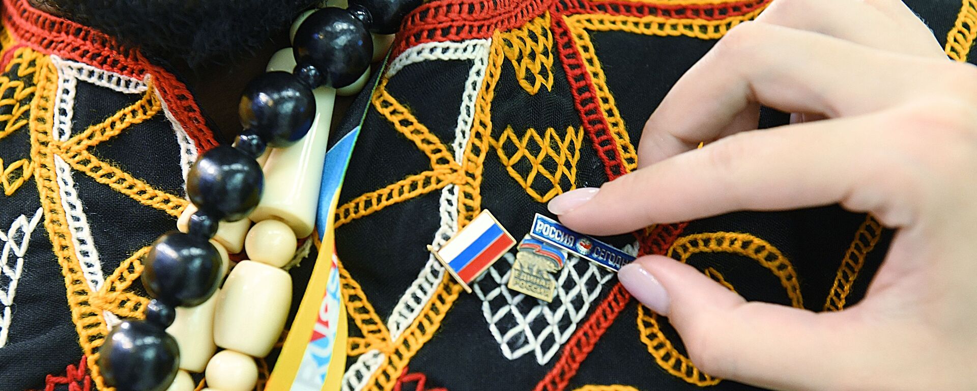 Participante do Fórum Rússia–África, em Sochi, recebe broches da bandeira da Rússia e do logotipo da Rossiya Segodnya, em 24 de outubro de 2019 - Sputnik Brasil, 1920, 16.03.2023