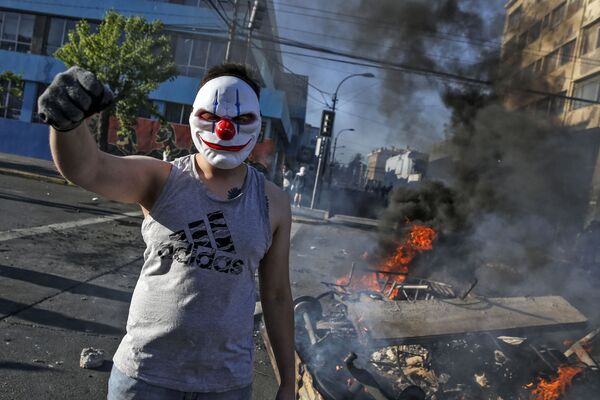 Manifestante com máscara durante os protestos em Santiago do Chile
 - Sputnik Brasil