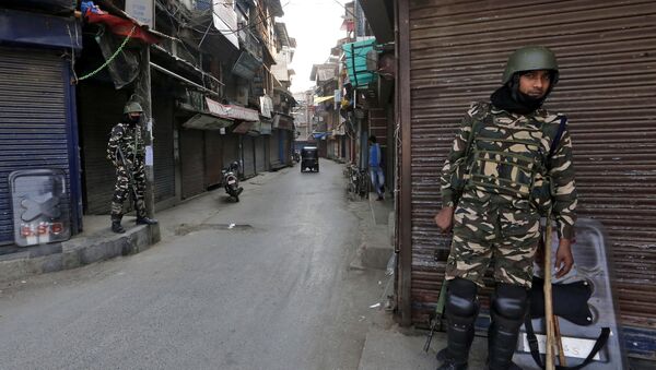 Pessoal da força de segurança indiana monta guarda em frente a lojas fechadas em uma rua de Srinagar, Caxemira - Sputnik Brasil