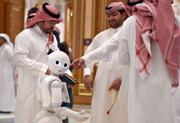 Visitantes do fórum Future Investiment Initiative ao lado de um robô em Riad, Arábia Saudita - Sputnik Brasil