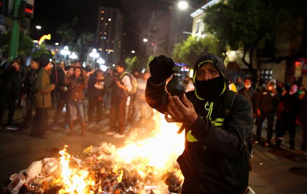 Manifestante segura uma bomba de gás lacrimogênio nas mãos, em meio à conflitos entre manifestantes na Bolívia, no dia 5 de novembro - Sputnik Brasil