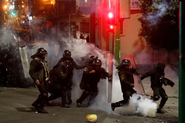 Tropa de choque tenta afastar bomba de gás lacrimogênio atirada por manifestante, durante confronto em La Paz, no dia 5 de novembro de 2019 - Sputnik Brasil