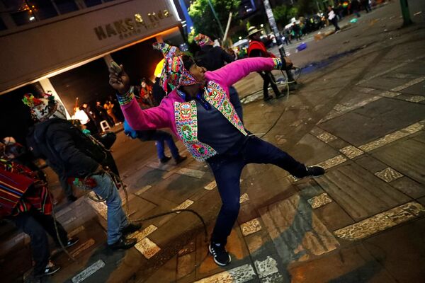 Homem com vestes típicas dos índios andinos joga pedras, durante confronto entre manifestantes em função dos resultados das eleições presidenciais de outubro de 2019 - Sputnik Brasil