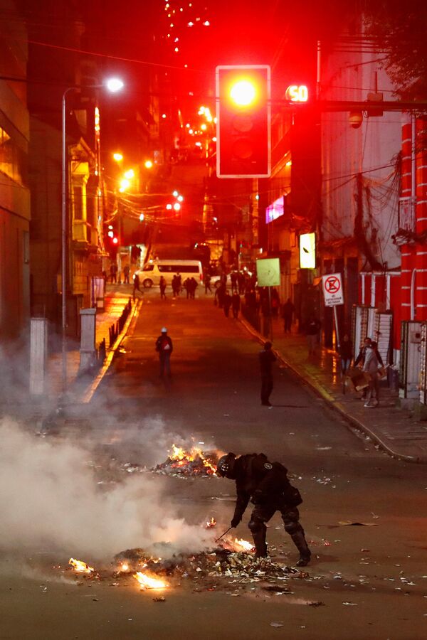 Tropa de choque observa fogo ateado durante confrontos entre manifestantes que acatam os resultados das eleições e manifestantes que acusam o governo de fraude eleitoral, em La Paz, em 5 de novembro de 2019 - Sputnik Brasil