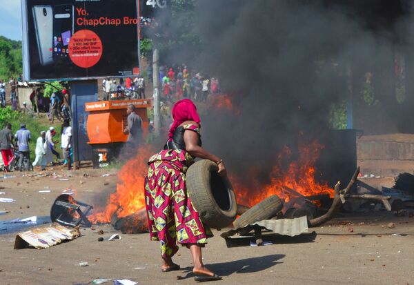 Mulher queima pneu durante funeral na capital da Guiné, Conacri. - Sputnik Brasil
