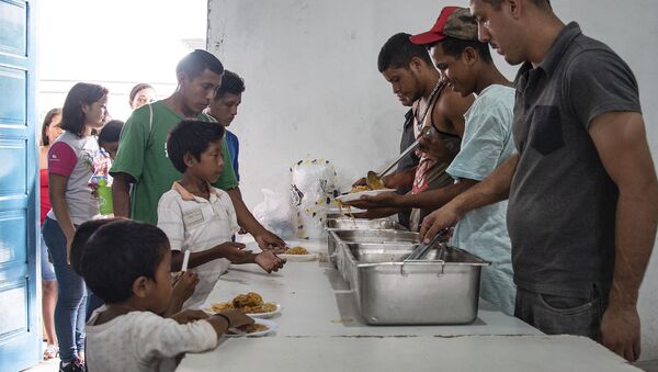 Distribuição de comida em centro de acolhida para refugiados venezuelanos. - Sputnik Brasil