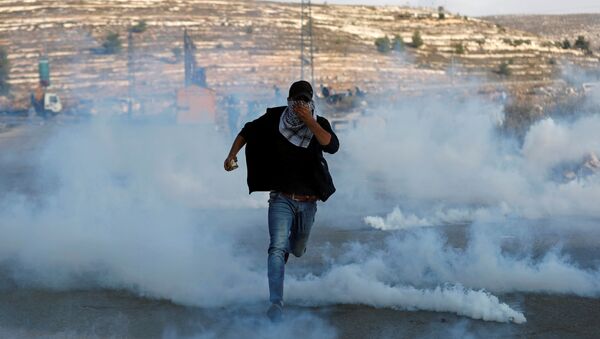Manifestante palestino corre das forças israelenses durante protesto próximo a um assentamento de Israel na Cisjordânia - Sputnik Brasil