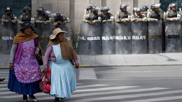 Mulheres passam na frente do palácio presidencial da Bolívia, que está sob forte proteção militar e policial, em 19 de novembro de 2019 - Sputnik Brasil