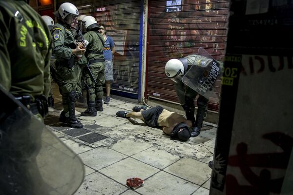 Polícia e um manifestante ferido na luta depois do anúncio dos resultados do referendo em Atenas, Grécia. - Sputnik Brasil