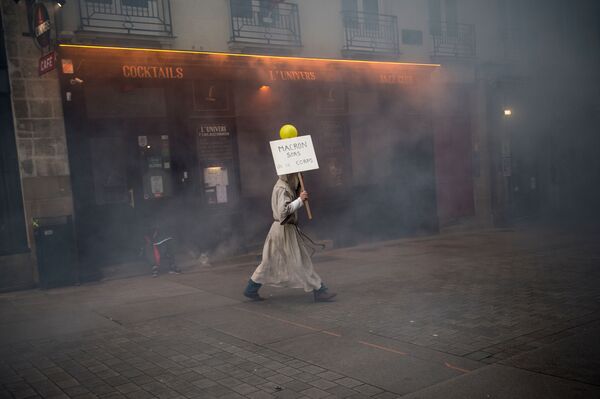 Homem vestido de monge carrega placa com os dizeres Macron saia deste corpo na cidade francesa de Nantes - Sputnik Brasil