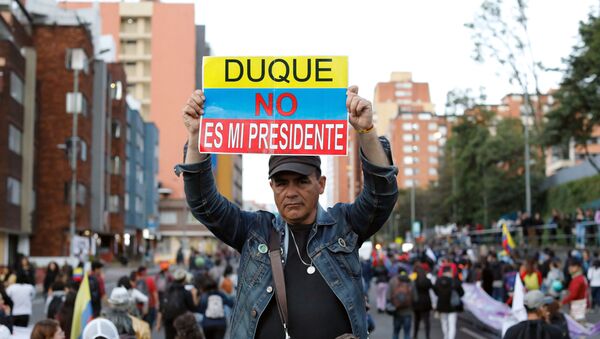 Manifestante exibe cartaz contra o presidente da Colômbia, Iván Duque, durante protesto em Bogotá, capital do país, em 25 de novembro de 2019 - Sputnik Brasil