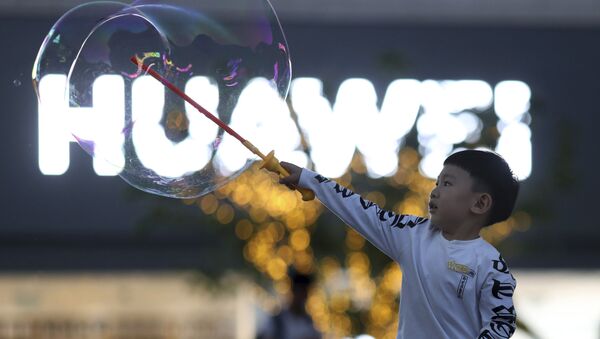 Criança brinca próxima ao logo da empresa Huawei, em Pequim (foto de arquivo) - Sputnik Brasil