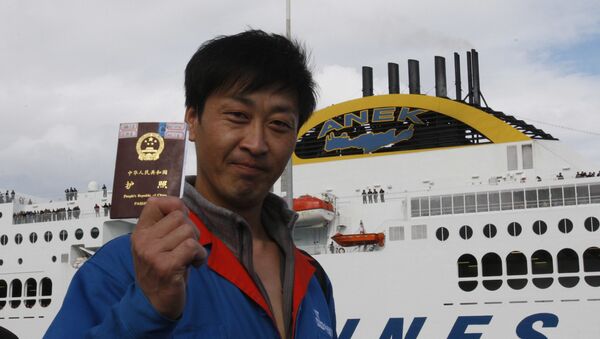 Cidadão chinês demonstra seu passaporte antes de embarcar em navio - Sputnik Brasil