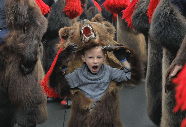 Uma criança vestindo fantasia de urso durante celebrações de Ano Novo em Comanesti, Romênia - Sputnik Brasil