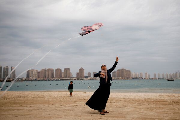 Mulher com traje muçulmano e uma pipa na praia em Doha, Qatar
 - Sputnik Brasil