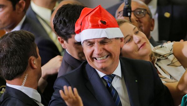 Presidente Jair Bolsonaro veste um adereço de Natal durante cerimônia no Palácio do Planalto - Sputnik Brasil
