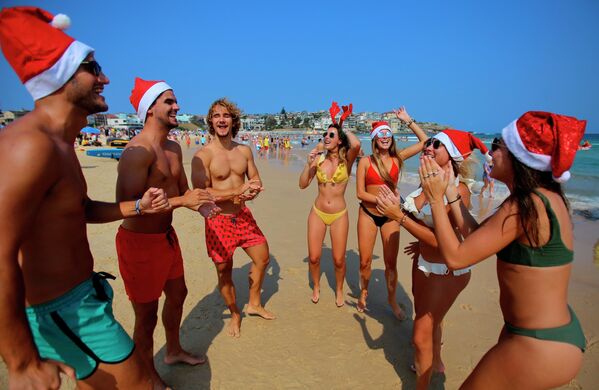 Turistas com trajes natalinos em uma praia de Sydney, Austrália - Sputnik Brasil