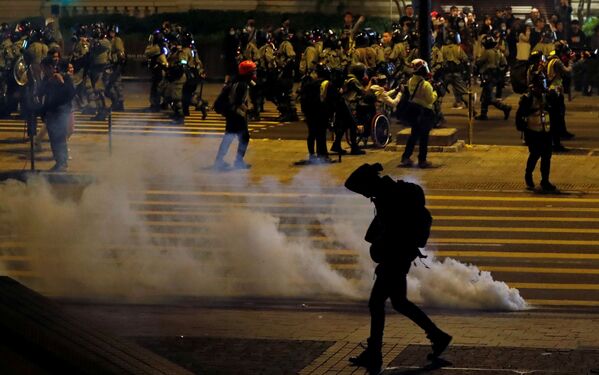 Manifestante antigovernamental passa ao lado de uma bomba de gás lacrimogênio na véspera de Natal em Hong Kong, China - Sputnik Brasil