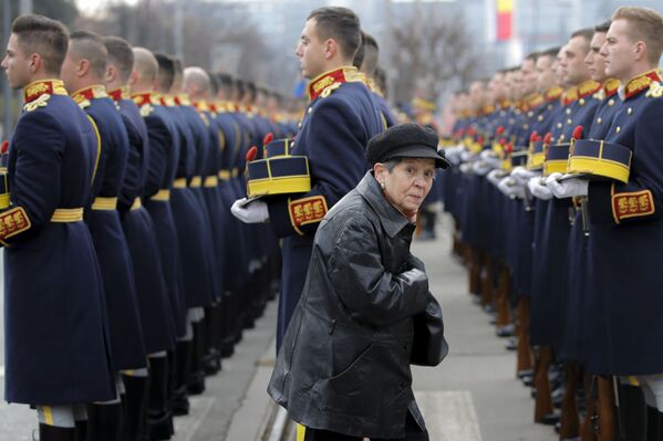 Mulher passa durante cerimônia dedicada aos mortos do levante anticomunista que resultou na queda do ex-líder romeno Nicolae Ceaucescu em dezembro de 1989 - Sputnik Brasil