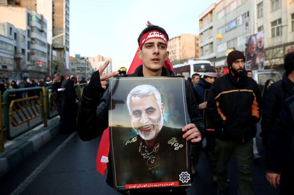 Homem leva retrato de Qassem Soleimani em cortejo fúnebre em Teerã, Irã - Sputnik Brasil