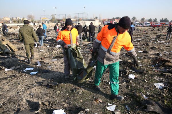 Socorristas em meio aos escombros do Boeing 737 do voo PS752 Teerã-Kiev, que caiu após decolar do Aeroporto Internacional Imã Khomeini, em Teerã - Sputnik Brasil