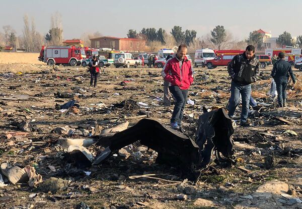 Pessoas observam os restos do avião ucraniano do voo PS752, que caiu perto do Aeroporto Internacional Imã Khomeini em Teerã, Irã - Sputnik Brasil