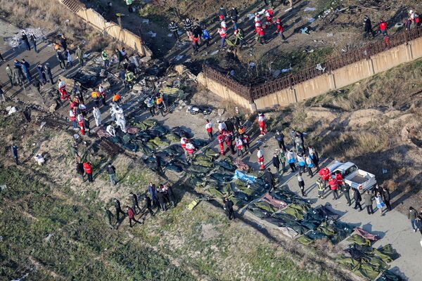 Equipes de resgate e moradores locais são fotografadas entre os corpos das vítimas da queda do voo PS752 Teerã-Kiev - Sputnik Brasil
